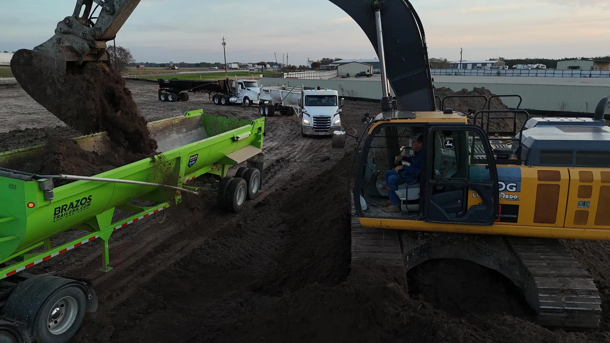 Heavy excavator working a dirt site at sunset in North Texas