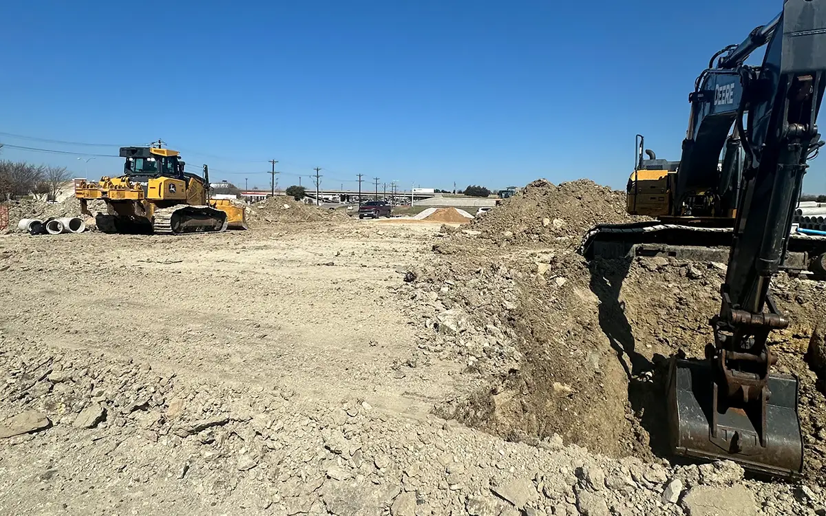 image of field of grey dirt with a machine